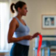 Person beim Reha-Training mit einem Thera-Band